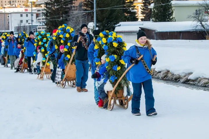 Eine Rennbänna mit blau-gelbem Rosenbogen im Umzug