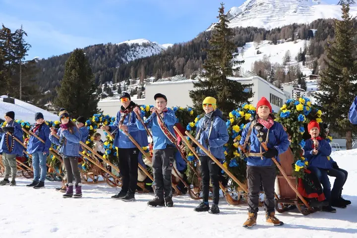 Kinder in blauen Jacken stehen mit ihren Rennbänna in einer Reihe
