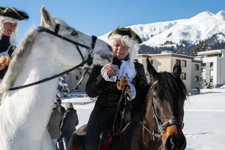 Zwei Füerriiter in historischen Kostümen bei ihren Pferden