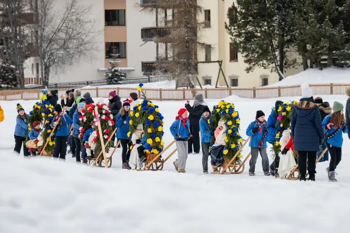 Die Kolonne der Rennbänna mit Kindern und Eltern auf der Schneefläche