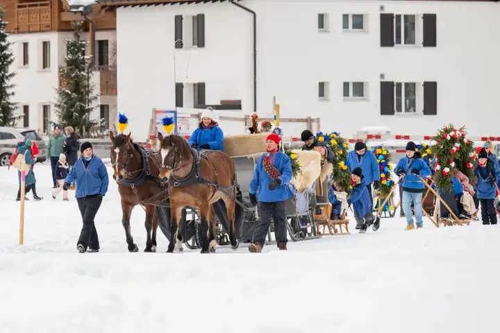 Die Kutsche mit zwei Pferden und geschmückte Rennbänna vor einem Haus